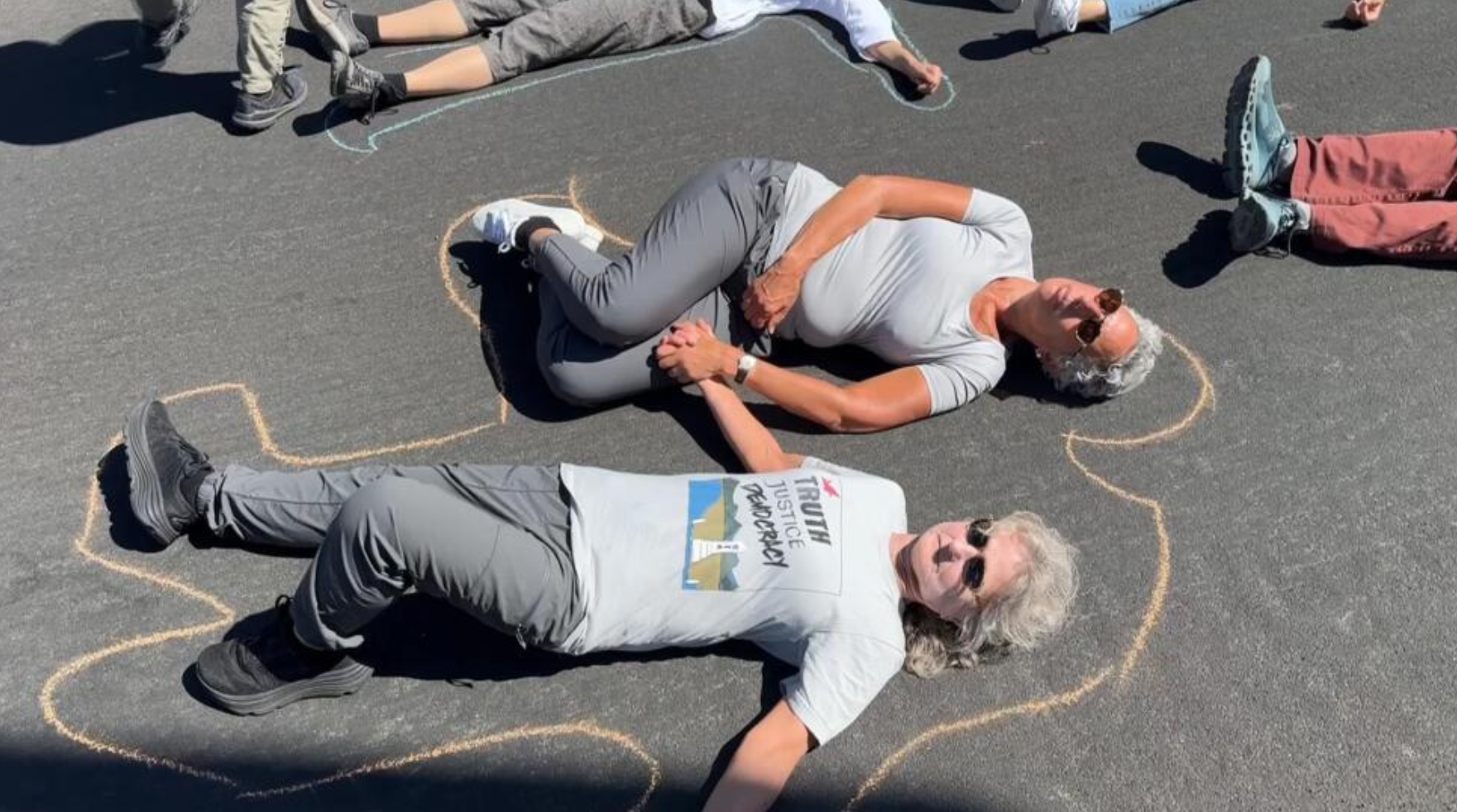 2025 Aug 6 protest die in LL labs two people lining on ground with chalk outlines as if they were dead